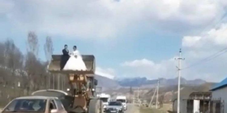 Аксыда жаңы үйлөнгөн жубайлар трактордун жүктөгүчүнө түшүп көчө кыдырышты (видео)