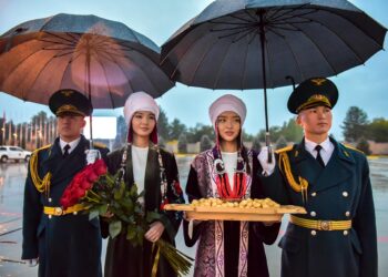 Кол чатыр менен сулууларды жаандан коргоп турган мырзалардын сүрөтү